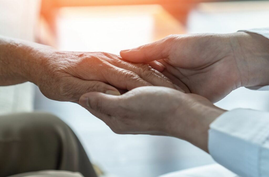 close up of a family member holding hand of their loved one with dementia