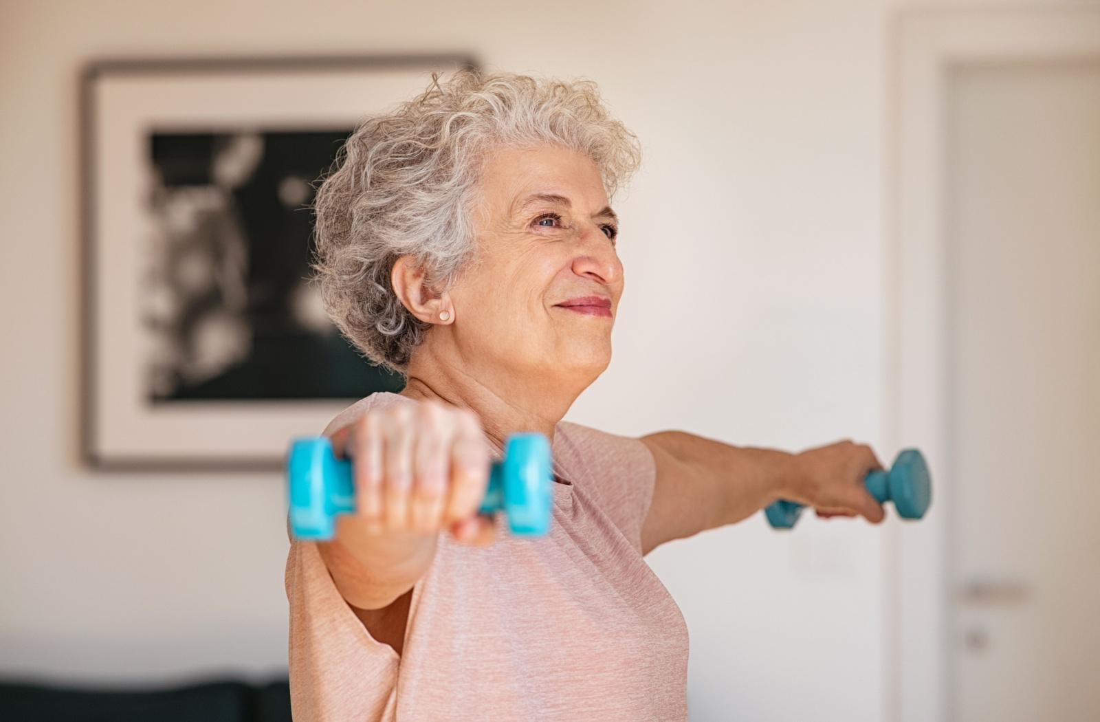 A senior woman lifting weights to improve bone density.