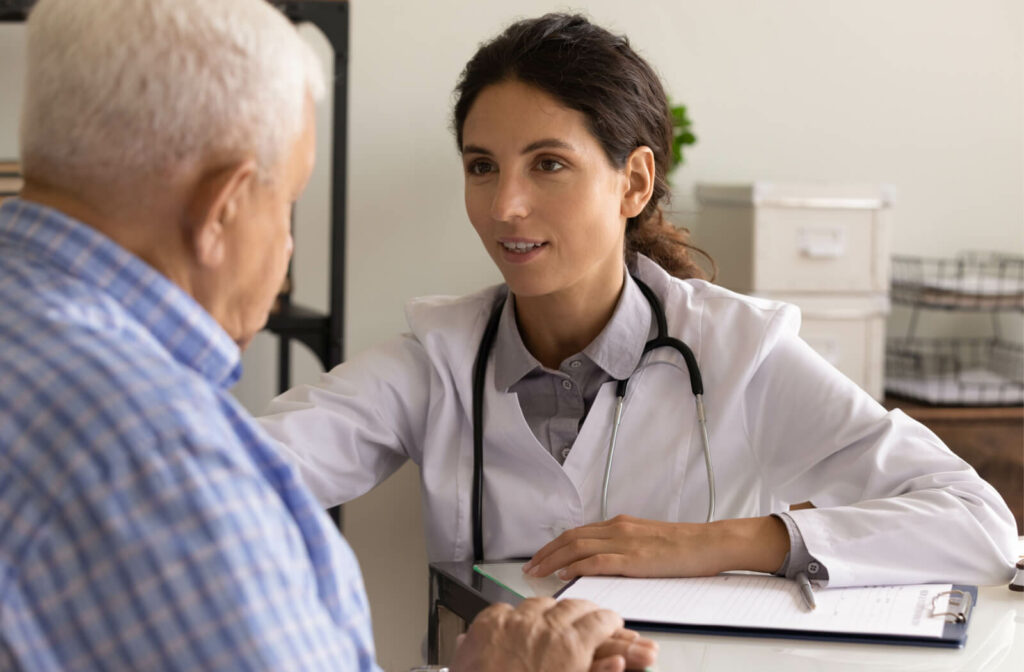 A woman physician conducting a health consultation with a senior gentleman in her office within a nursing facility.